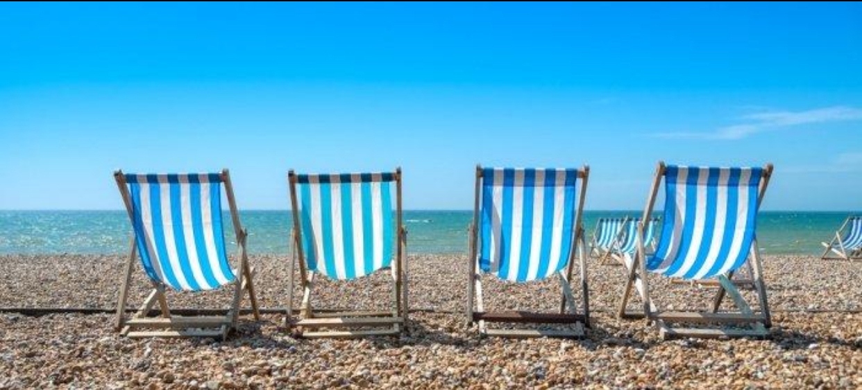 Blue and white striped deckchairs on the beach by the sea