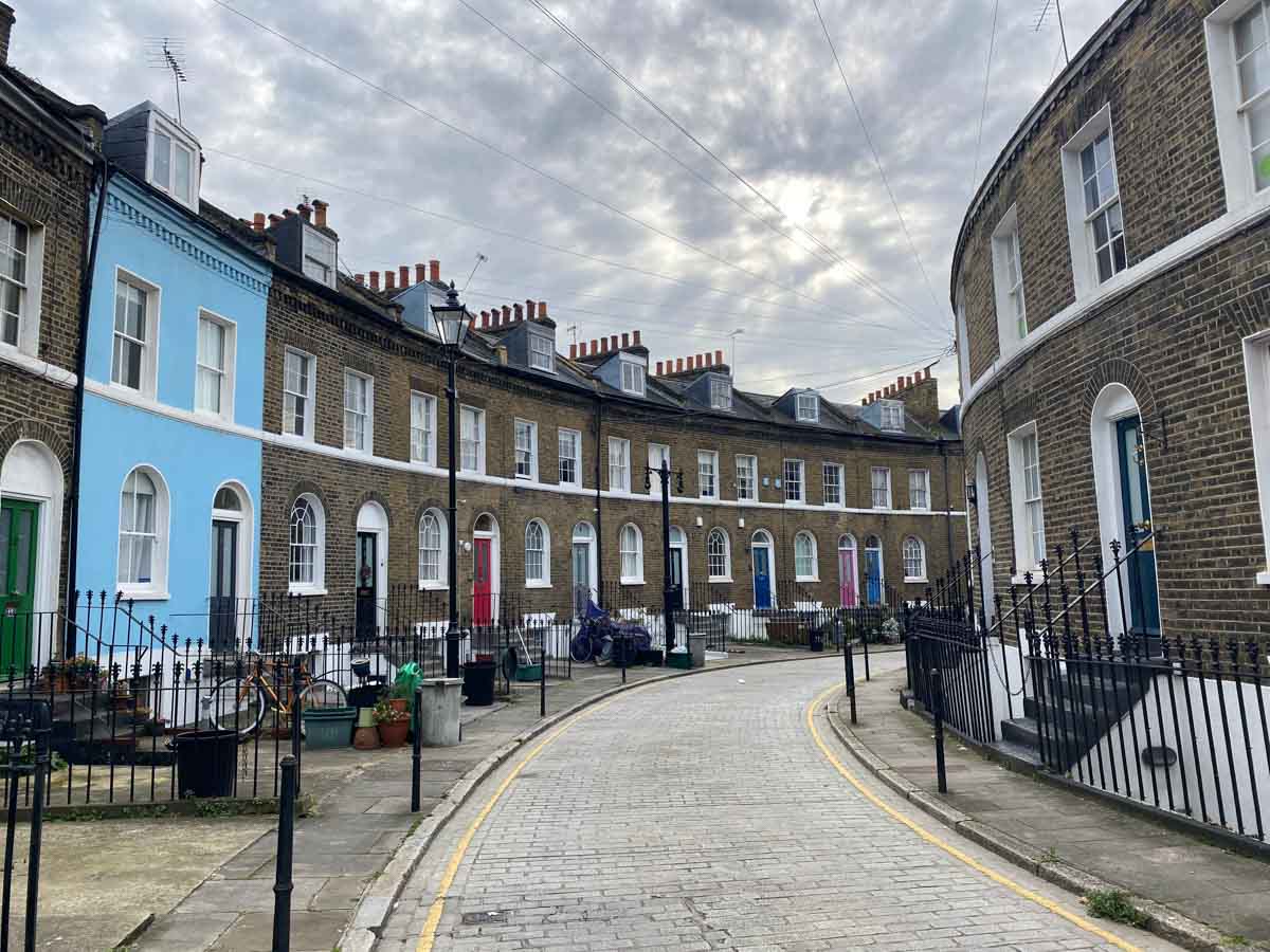 A curved Islington street of period houses with pastel front doors