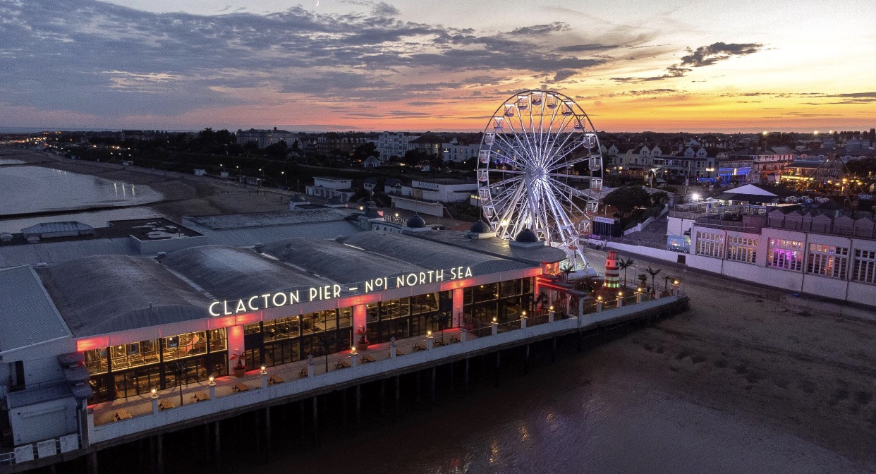 Clacton Pier with its big wheel lit up at sunset